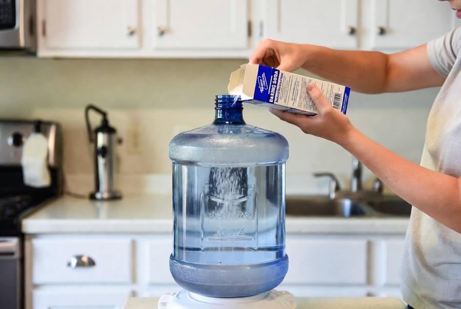 baking soda being used to clean 5 gallon water jug