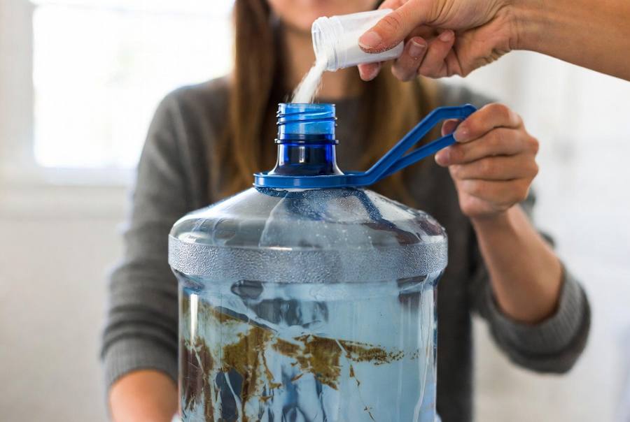 sanitizing the nozzles of the dirty 5 gallon water jugs that needs to be cleaned